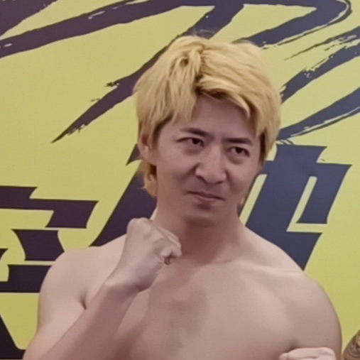 Chen Qiushi holding up a fist in front of an event backdrop.