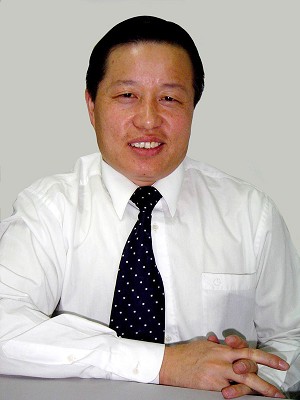 Gao Zhisheng wearing a white shirt and tie, seated at a desk.