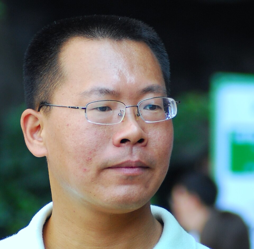 Close-up photograph of Teng Biao wearing thin-framed glasses.