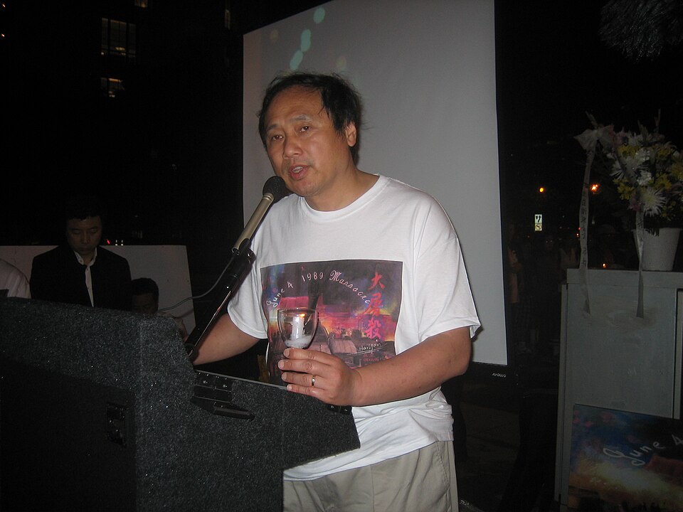 Wang Juntao speaking beside a lectern.