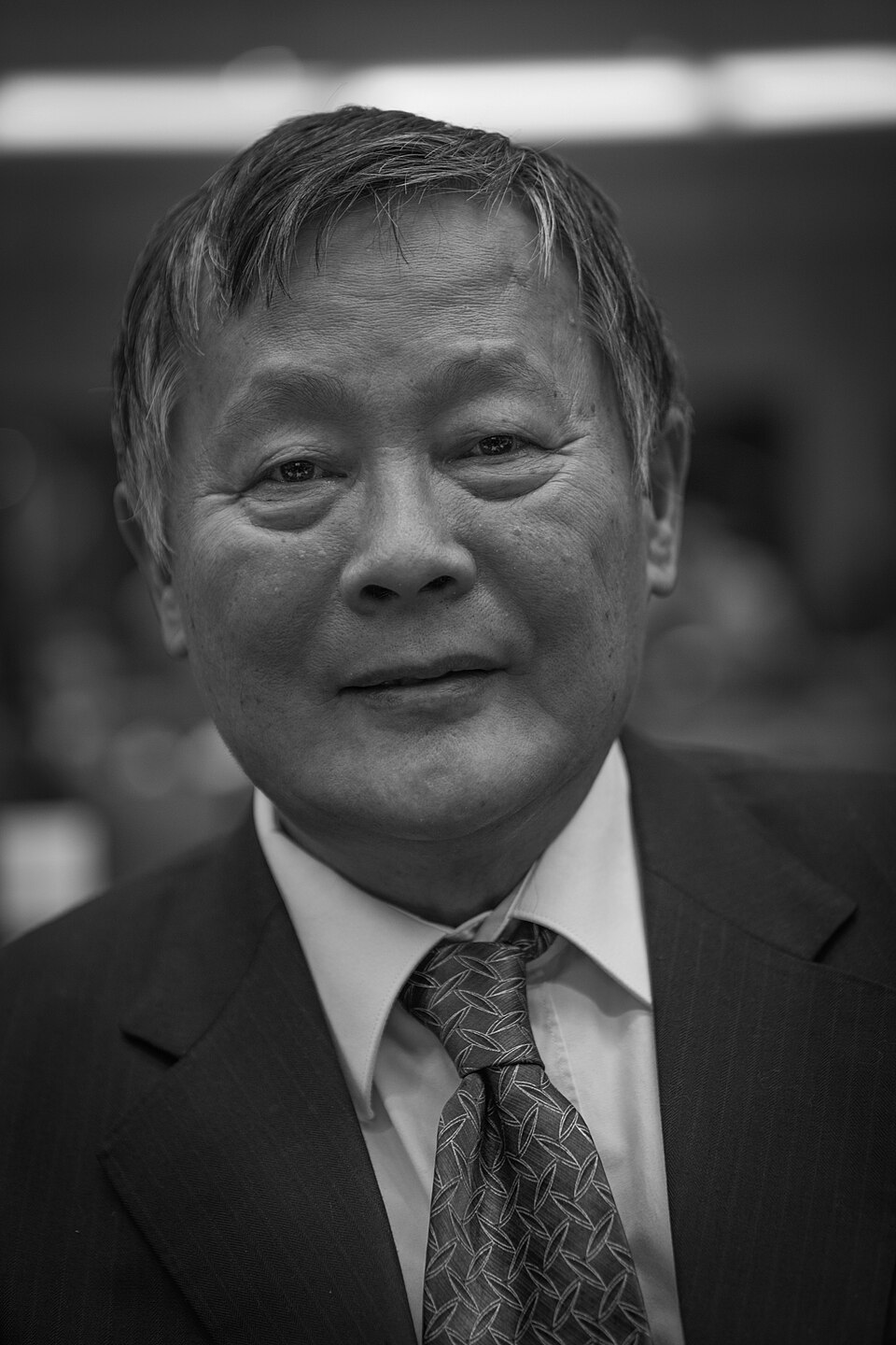 Black-and-white portrait of Wei Jingsheng in a suit and tie.